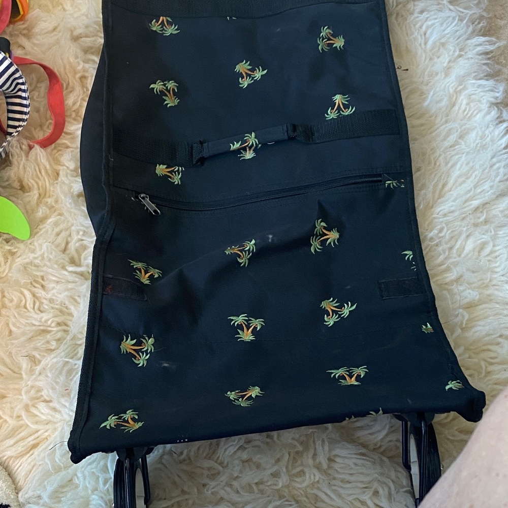 Luggage cart with wheels that fold under the bag. Black nylon fabric